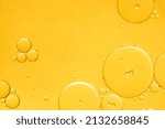 Small photo of Golden yellow abstract oil bubbles or face serum background. Oil and water bubbles macro photography.