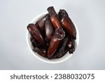 Small photo of Top view of traditional edible araucaria seeds. White bowl of Pinhao (pinion nuts), on white background.