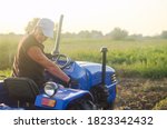 A Farmer On A Tractor Drives...