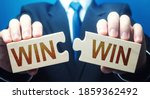 Small photo of Man holding two puzzles with Win-Win words. A negotiation strategy makes all parties succeed. Mutual benefit and good contract terms. Compromise, perfect. Consent and satisfaction. Trade and diplomacy