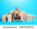 Small photo of Money bag among town houses figurines. Municipal budgeting. Rich city. Rental business. Realtor services. Sale of real estate. property taxes. Tax collection, investment in city development.