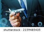Small photo of A plane taking off in the hands of a businessman and a pin location symbol. Business tourism. Organization of air traffic. Business class flights. Support financial program for civil aviation