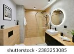 Small photo of Decorated modern bathroom in boho style with a walk-in cabin, rain shower column and black built-in cabinets, with honey-colored wood-imitating tiles and round led light mirror