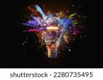 Electric light bulb exploding with paint and glass, a creative idea. Business and technology. Think different, concept. New thinking and brainstorming