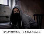 Small photo of Low key portrait-Woman wearing black masks staring ahead at stress,in dark and dirty room,concept of loneliness, sadness from bully and browbeat, and depression and separation from society