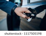 Close-Up Shot of a Professional Businessman with his Hand Firmly on the Car Door Handle, Demonstrating Elegance and Confidence while Opening the Door to his Vehicle 