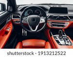 Expensive car interior with steering wheel, multimedia dashboard and gearbox handle	