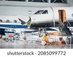 Small photo of Maintenance and service check of an airplane in the large white hangar. Airplane workshop and repair station