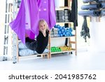 Portrait young smiling girl practice in aero stretching swing in purple hammock in fitness club. kids Aerial flying yoga exercises.