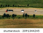 Top down view of truck, minivan and car on road from drone pov, vehicles driving down the roadway in summer afternoon
