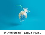 Ban plastic pollution. Globe wrapped in a plastic bag and a straw sticking out of the globe. Creative concept