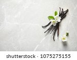 Vanilla sticks and flowers on light background