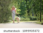 Young woman and her dog spending time together outdoors. Pet care