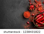 Flat lay composition with powdered and raw chili peppers on dark background. Space for text