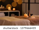 Burning candles and aromatic reed freshener on table in spa salon, space for text