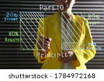 Small photo of Woman writing 80/20 rule representation on glass board in office, closeup. Pareto principle concept