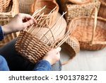 Woman weaving wicker basket...