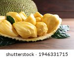 Fresh exotic jackfruit bulbs on wooden table, closeup