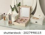 Jewelry boxes with stylish golden bijouterie on white dressing table