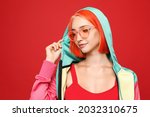 Beautiful young woman with bright dyed hair on red background