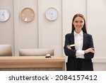 Small photo of Portrait of beautiful receptionist near counter in hotel