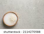 Small photo of Rice soaked in water on light grey table, top view. Space for text