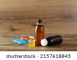Small photo of Cough syrup and lozenges on wooden table