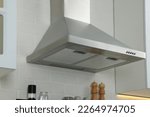Modern range hood over shelf with spices in kitchen