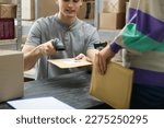 Woman and post office worker with scanner reading parcel barcode at counter indoors, closeup