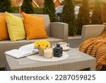 Small photo of Beautiful rattan garden furniture, soft pillows and different decor elements outdoors