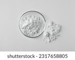 Small photo of Petri dish and calcium carbonate powder on white background, top view