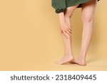 Small photo of Closeup view of woman suffering from varicose veins on yellow background. Space for text