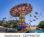 Small photo of SACRAMENTO, CA, U.S.A. - JULY 18, 2023: Photo of the midway ride the Wave Swinger at the California State Fair, held every summer in July at the Cal Expo site.