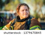 Female firefighter isolated in full bunker gear after a fire. 
