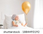 Small photo of Little girl with golden balloon undergoing course of chemotherapy in clinic. Childhood cancer awareness concept