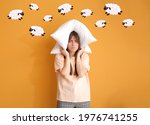 Small photo of Tired woman with pillow on color background. Concept of sleep deprivation