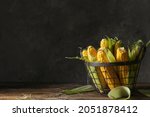 Basket with fresh corn cobs on...