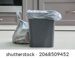 Bag with garbage and rubbish bin in kitchen
