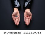 Hands with blue and red pills on dark background. Concept of choice