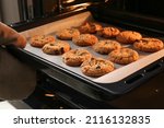 Small photo of Baking tray with tasty homemade cookies taking out from oven
