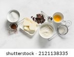 Bowl with butter and ingredients for preparing chocolate brownie on white background