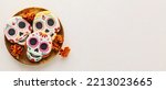 Small photo of Wooden tray with tasty cookies in shape of skull for Mexico's Day of the Dead (El Dia de Muertos) on light background with space for text