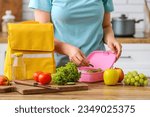 Woman packing fresh meal into...