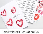 Greeting cards with text I LOVE YOU and lipstick kiss marks on grey background, closeup. Valentine's Day celebration