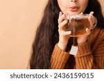 Young woman with glass cup of...
