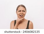 Small photo of Young woman suffering from jaw pain holding her chin isolated on light background. Inflammation of cervical lymph nodes, Diseases of ENT organs, facial, trigeminal nerve, toothache, dislocation of jaw