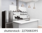 A kitchen with grey cabinets, lights mounted above the subway tile backsplash, and shelves and lights hanging above the island. No labels or brands.