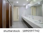 Empty public bathroom with lavatory and wide wall mirror, concept for public toilets.
