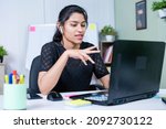 Small photo of young india businesswoman convincing client about project on video call while working at office - concept of business skills, woman empowerment and communication