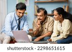 Small photo of Indian banker explaining about insurance policy or savings scheme on laptop to senior couple while sitting on sofa at home - concept of banking support, and bonding